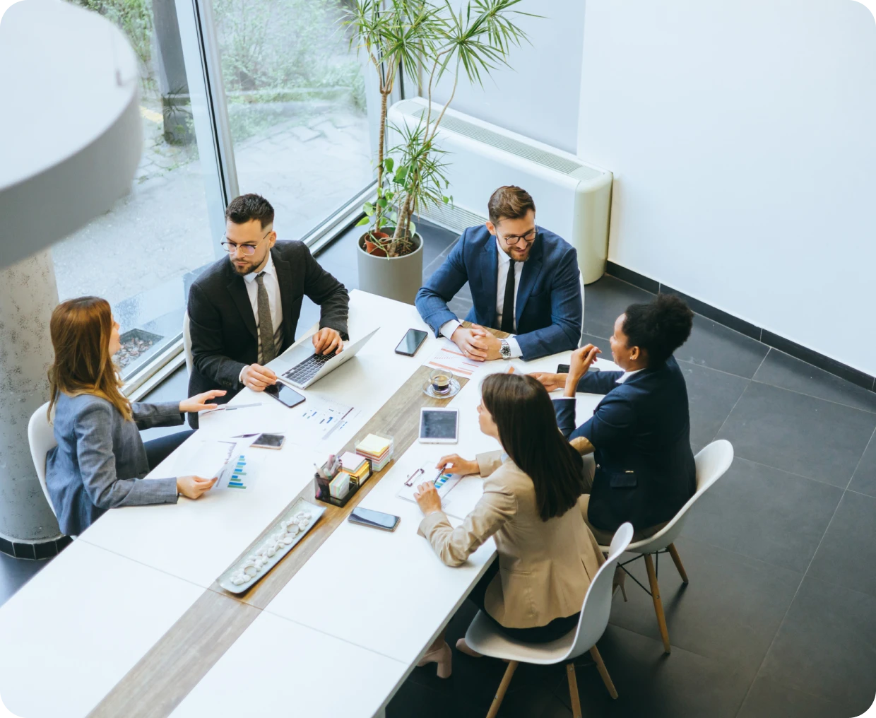 Business meeting with five people at table.